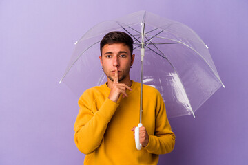 Young caucasian man holding umbrella isolated on purple background  keeping a secret or asking for silence.