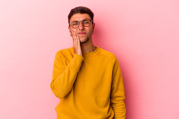 Young caucasian man with tattoos isolated on yellow background  having a strong teeth pain, molar ache.