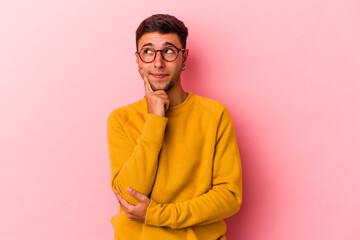 Obraz premium Young caucasian man with tattoos isolated on yellow background contemplating, planning a strategy, thinking about the way of a business.