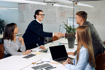 Two young man shake their hands after successful deal.