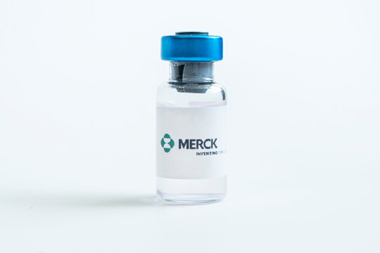 Vials of liquid on a white table and the logo of a large pharmaceutical company.