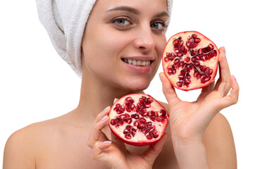 close-up of a beautiful middle-aged woman with a cut pomegranate in her hands on a white...