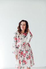 portrait of a beautiful woman in a dress with flowers on a white background