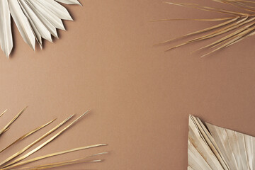 Tropical natural background with palm leaf on brown. Flat lay, copy space