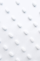 White pills on a white background. Oblong and round pills close-up. Healthcare and medicine.	
