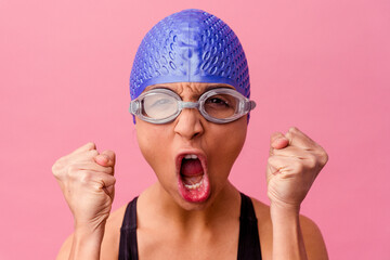 Young latin swimmer woman wearing diving googles and cap excited ready to swim - obrazy, fototapety, plakaty