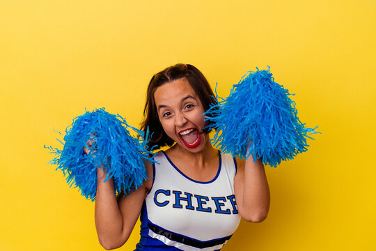 Young cheerleader woman isolated on yellow background