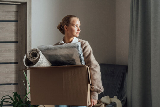 Woman with carton relocating in new apartment