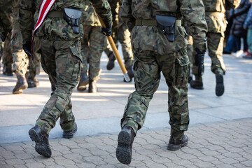 Soldiers march in parade step in full uniform. Rear view.