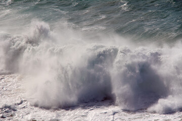 Ocean wave with water foam.
A big wave in the Atlantic Ocean with a strong wind. 
