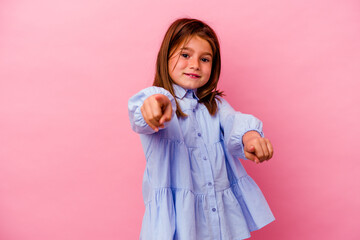 Little caucasian girl isolated on pink background  cheerful smiles pointing to front.