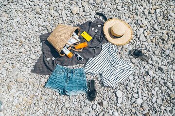 overhead view of beach stuff blanket with sun protection cream straw hat with bag