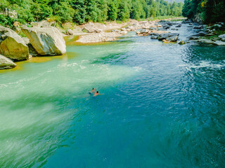 Obraz premium two men swimming in mountain river