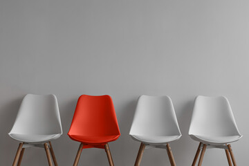 Three white chairs and red on gray wall background in office or room - obrazy, fototapety, plakaty