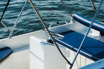 Motorboat on a lake background. Shiny steering wheel. Holiday water activity. Modern boat moored in port. Small boat rental withour licence.