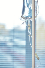 Fototapeta na wymiar Close-up of IV tube. Action. Dropper with drug slowly dripping down tube. IV tubes for sick patient after surgery.