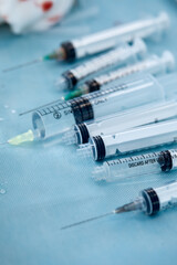 Many syringes on a blue sheet in operation room. Different sizes of syringes ready to be used