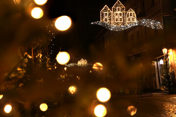 Obraz na płótnie Canvas Defocused magical Christmas background. New Year lights on street of night festive city