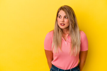 Young russian woman isolated on yellow background being shocked because of something she has seen.