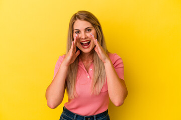 Young russian woman isolated on yellow background shouting excited to front.
