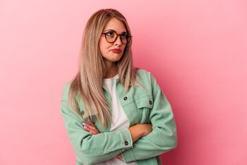 Young russian woman isolated on pink background tired of a repetitive task.