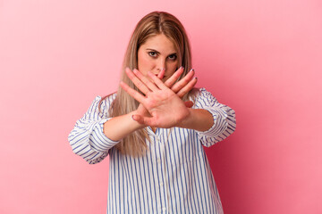 Young russian woman isolated on pink background doing a denial gesture