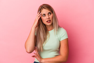 Young russian woman isolated on pink background being shocked, she has remembered important meeting.