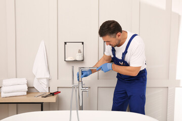 Fototapeta na wymiar Professional plumber installing water tap in bathroom