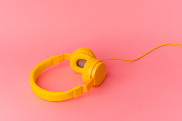 Yellow headphones isolated on pink background
