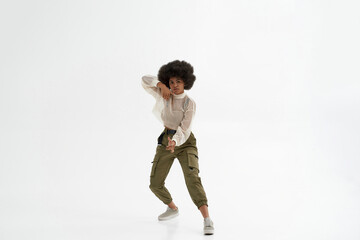 Serious black woman dancing on white background