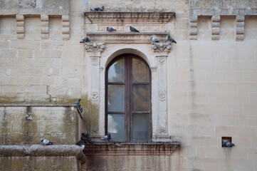 Fototapeta na wymiar Ancient Castle Window with Pigeons. Salento, Italy