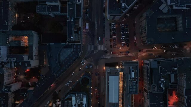 Aerial birds eye overhead top down panning view of night city. Cars driving through street intersection. Warsaw, Poland