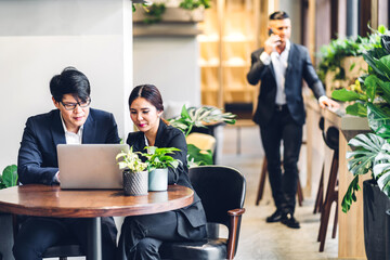 Group of asian business discussing meeting strategy sharing ideas thoughts with project.Creative business people working with laptop computer in green plant terrace decorated modern workloft