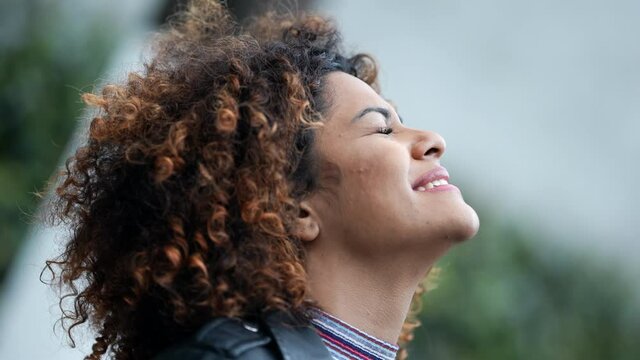 Successful black woman celebrating achievement closing eyes feeling relief