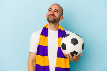 Young sport bald man wearing a scarf isolated on blue background  dreaming of achieving goals and purposes