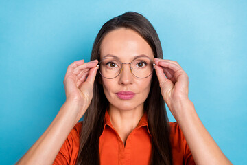 Photo of serious confident young woman wear red shirt arms spectacles isolated blue color background