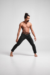 Handsome sporty black guy dancing in studio.