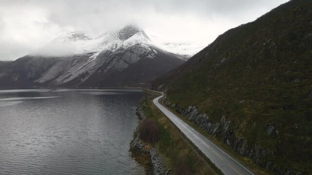 Narrow Road By The Mountain And Scenic View of The Stetind In Norway - aerial shot