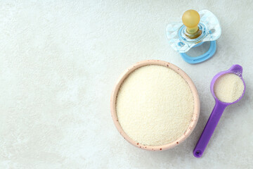 Concept of baby food with рowdered milk on white textured background