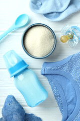 Concept of baby food with рowdered milk on white wooden background