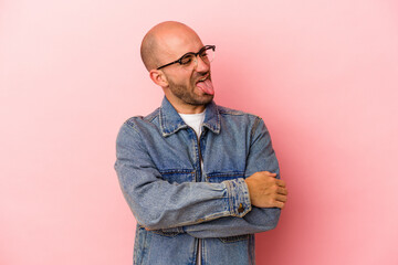 Fototapeta premium Young caucasian bald man isolated on pink background funny and friendly sticking out tongue.