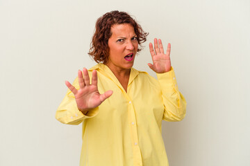 Middle age latin woman isolated on white background being shocked due to an imminent danger