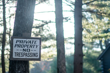 Private property sign in a woods outdoor environment, farm house in nature.