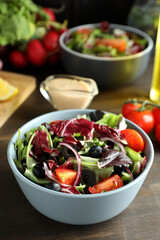 Concept of tasty food with vegetable salad with tahini sauce on wooden background