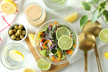 Concept of tasty food with vegetable salad with tahini sauce on white wooden background