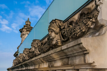 Obraz premium Lovely close-up view of sculptured heads on the facade of the Reichstag building in Berlin, Germany. The sandstone carvings are on the roof below the glass balustrade. 
