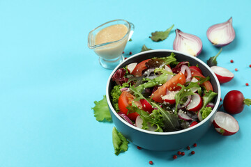 Concept of tasty food with vegetable salad with tahini sauce on blue background