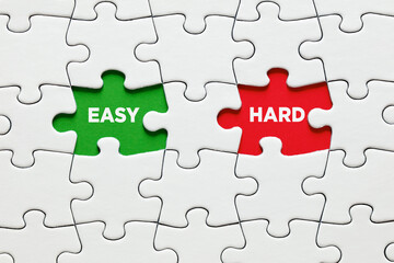 Fototapeta premium Missing puzzle pieces with the words easy versus hard. To make a choice between the options of easy or hard way.