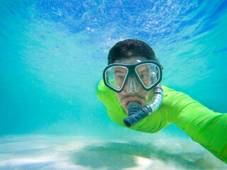 Snorkeling Diver wearing green shirt, in the Caribbean sea of ​​B&aacute;varo beach, Punta Cana, Dominican Republic