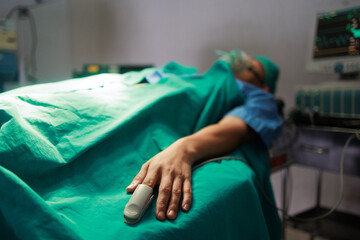 The close up of patient finger with heart rate monitor.